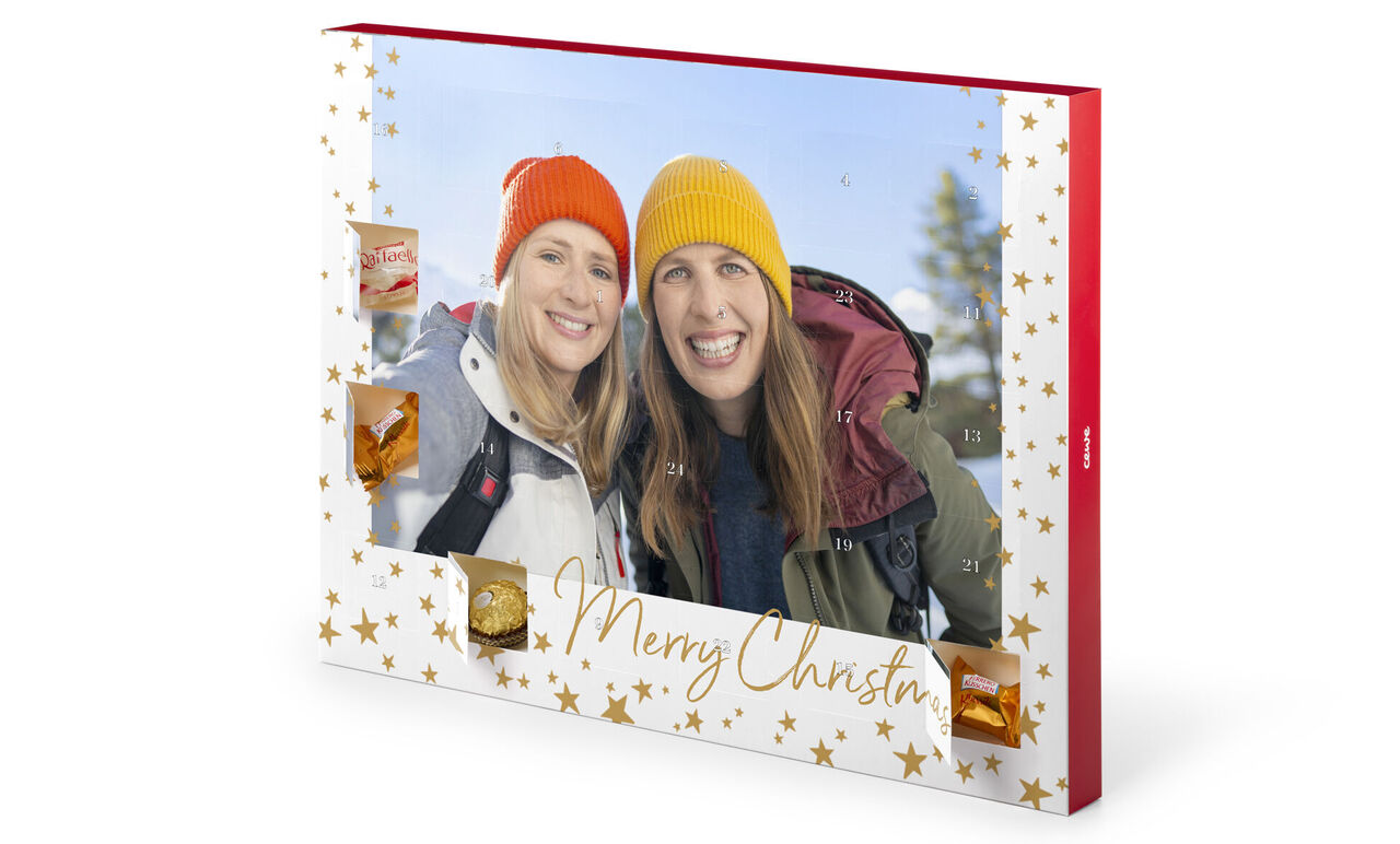 Färggranna julhattar bärande personer står i en vinterskog framför en julkalender. En grön lapp säger att det är av förnyelsebara råvaror.