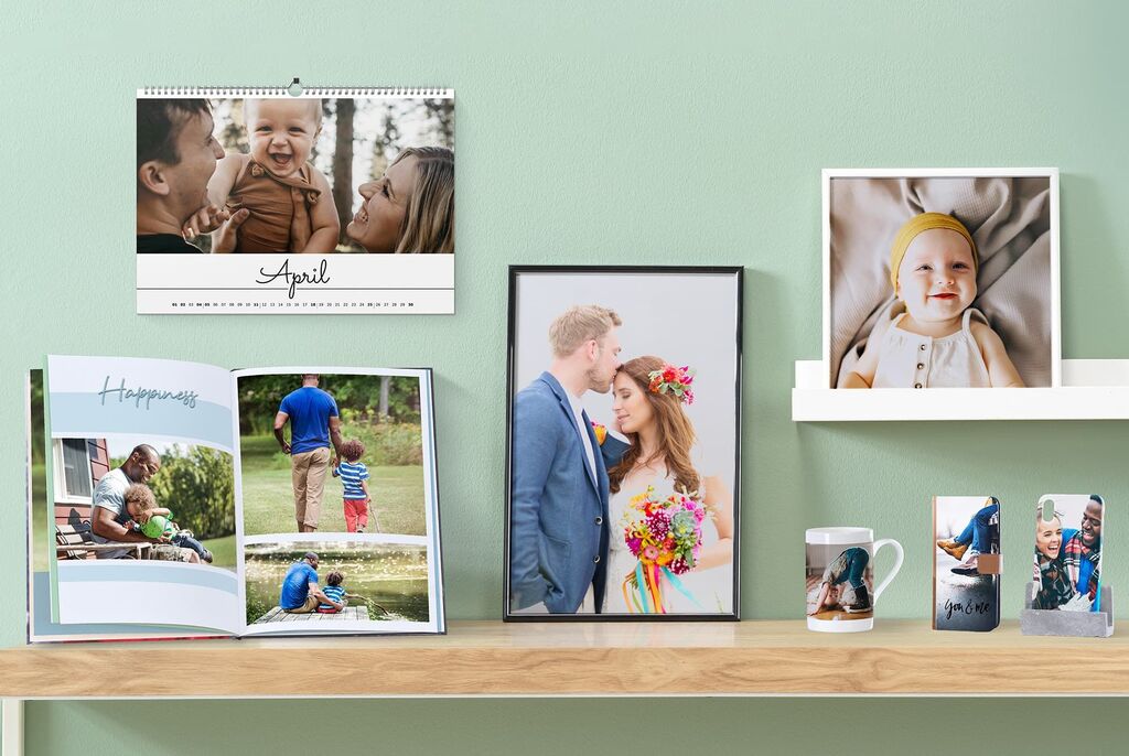 Ett stilrent bord med olika fotoprodukter: en kalender, en inramad bild, en fotobok och en mugg