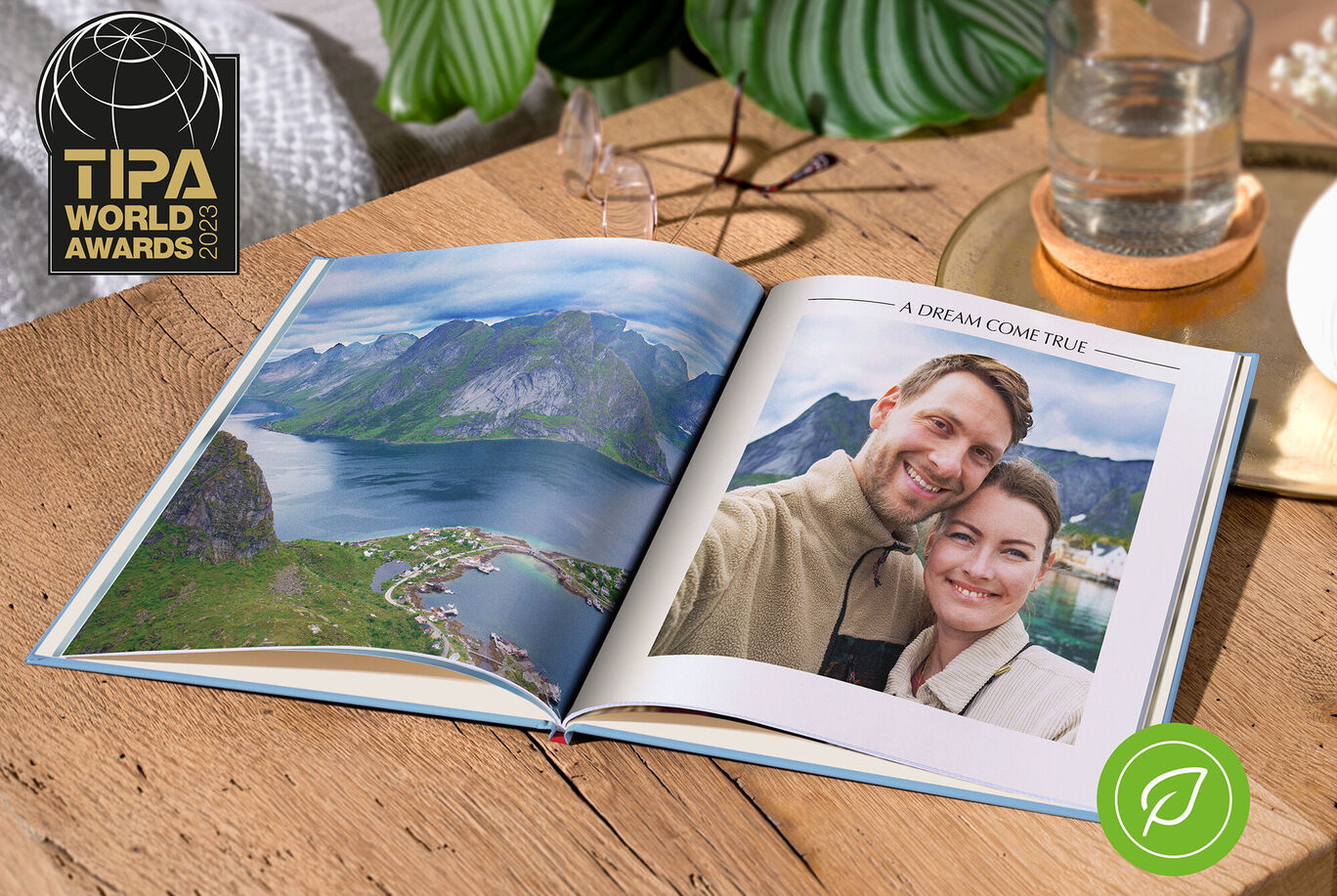 En öppen CEWE fotobok visar en fantastisk landskap och ett fint minne av två personer. Scenerna visar en imponerande utsikt över gröna berg och en klar himmel.