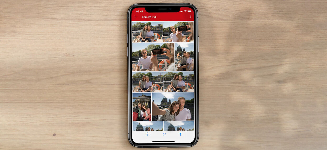 En smartphone-skärm visar olika bilder på glada människor en solig dag.
